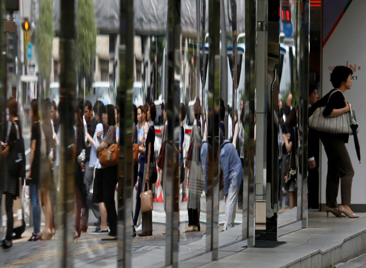 People are reflected in the windows of a department store in a shopping district in Tokyo, Japan, on June 29, 2016. (Toru Hanai/Reuters)