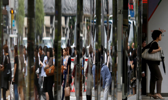 People are reflected in the windows of a department store in a shopping district in Tokyo, Japan, on June 29, 2016. (Toru Hanai/Reuters)