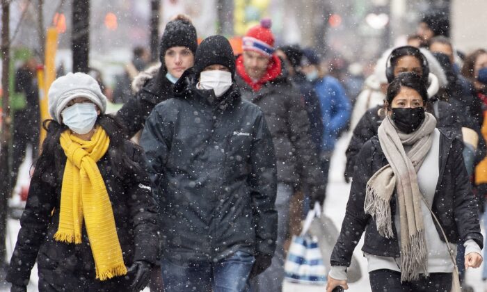  
People walk along Ste-Catherine Street in Montreal on Dec. 4, 2021. (The Canadian Press/Graham Hughes)
