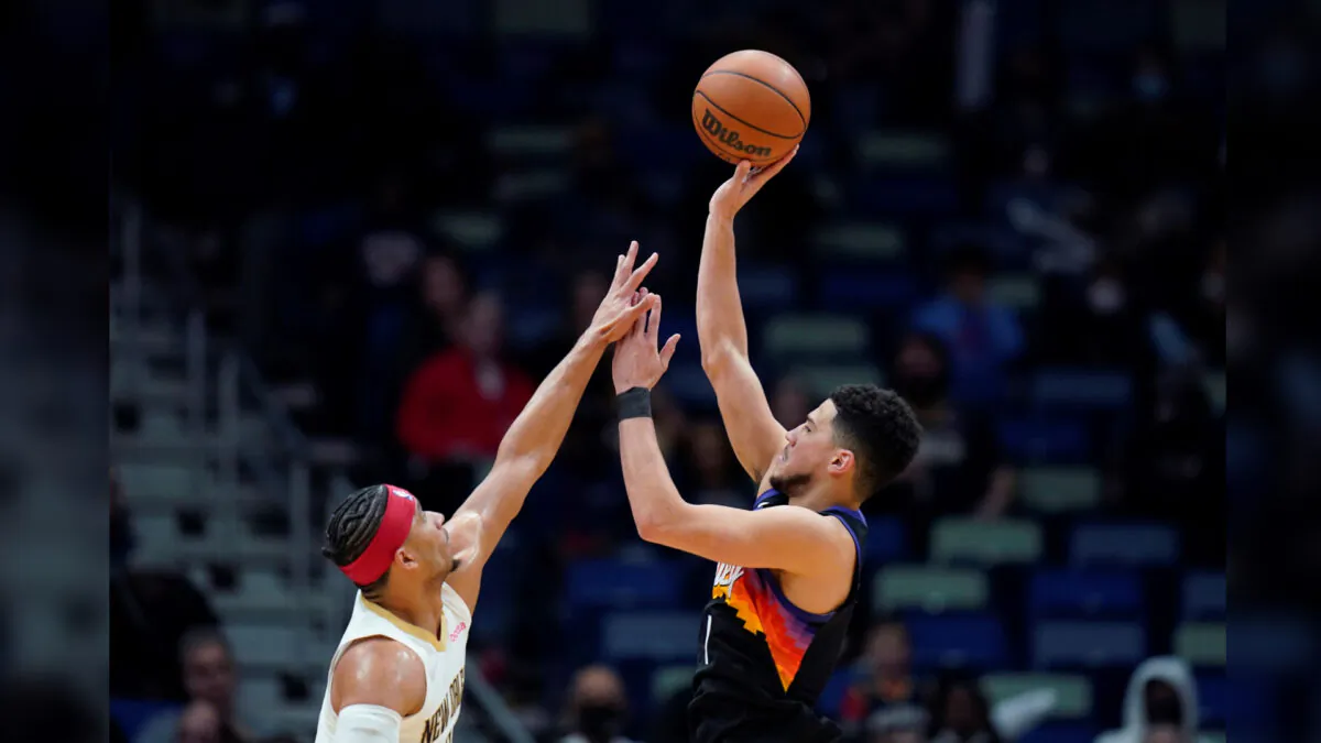 Phoenix Suns guard Devin Booker (1) shoots against New Orleans Pelicans guard Josh Hart in the first half of an NBA basketball game in New Orleans, on Jan. 4, 2022. (Gerald Herbert/AP Photo)