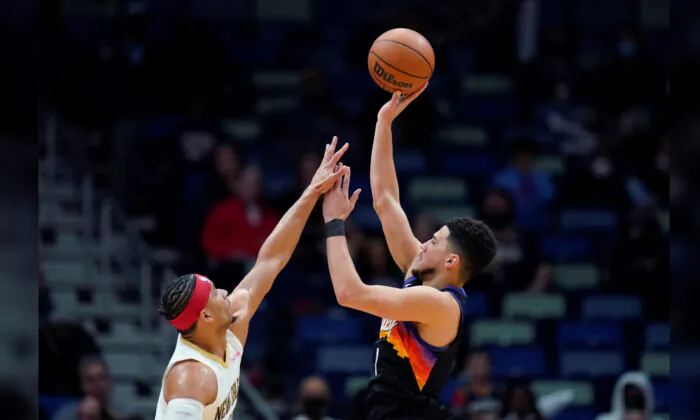 Phoenix Suns guard Devin Booker (1) shoots against New Orleans Pelicans guard Josh Hart in the first half of an NBA basketball game in New Orleans, on Jan. 4, 2022. (Gerald Herbert/AP Photo)