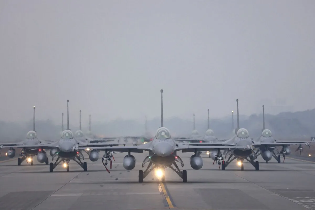 Taiwan C-130 flies12 F-16V fighter jets perform an elephant walk during an annual New Year's drill in Chiayi, Taiwan, on Jan. 5, 2022. (Ann Wang/Reuters)