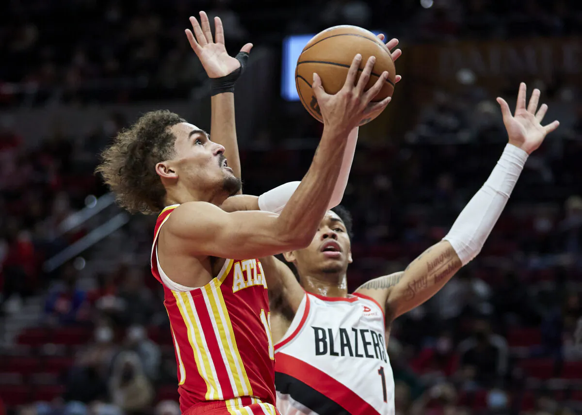 Atlanta Hawks guard Trae Young (L) shoots over Portland Trail Blazers guard Anfernee Simons during the first half of an NBA basketball game in Portland, Ore., on Jan. 3, 2022. (Craig Mitchelldyer/AP Photo)