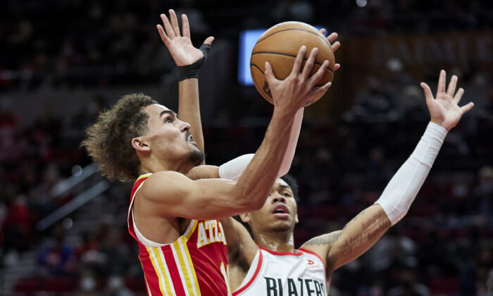 Atlanta Hawks guard Trae Young (L) shoots over Portland Trail Blazers guard Anfernee Simons during the first half of an NBA basketball game in Portland, Ore., on Jan. 3, 2022. (Craig Mitchelldyer/AP Photo)