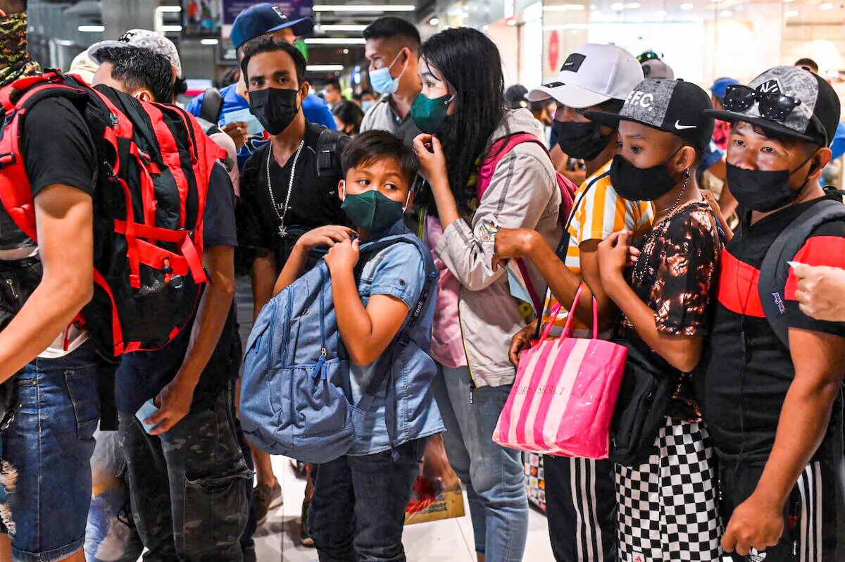 People wait to ride a bus going to provinces at a bus terminal in Paranaque City, Metro Manila, Philippines, on Dec. 30, 2021. (Lisa Marie David/Reuters)