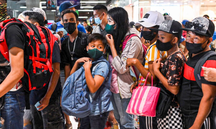 People wait to ride a bus going to provinces at a bus terminal in Paranaque City, Metro Manila, Philippines, on Dec. 30, 2021. (Lisa Marie David/Reuters)