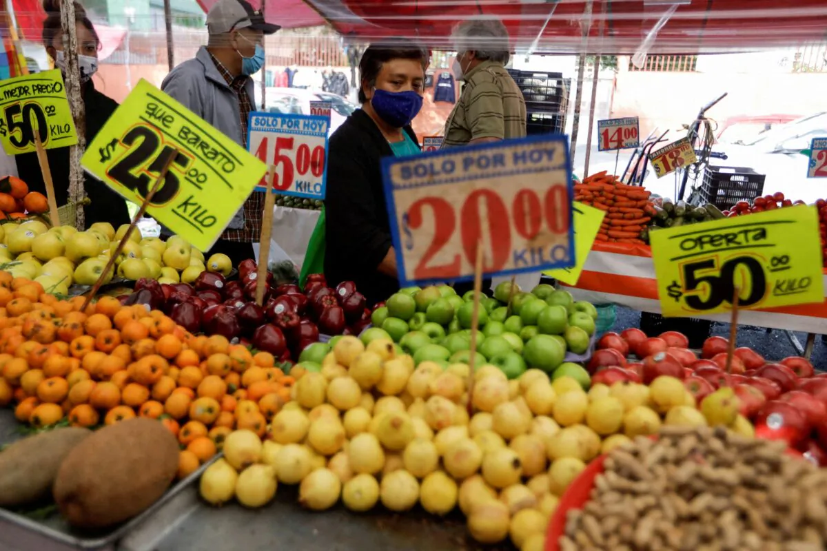 Customers walk past a fruit stall at a street market in Mexico City on Dec. 17, 2021. (Luis Cortes/Reuters)
