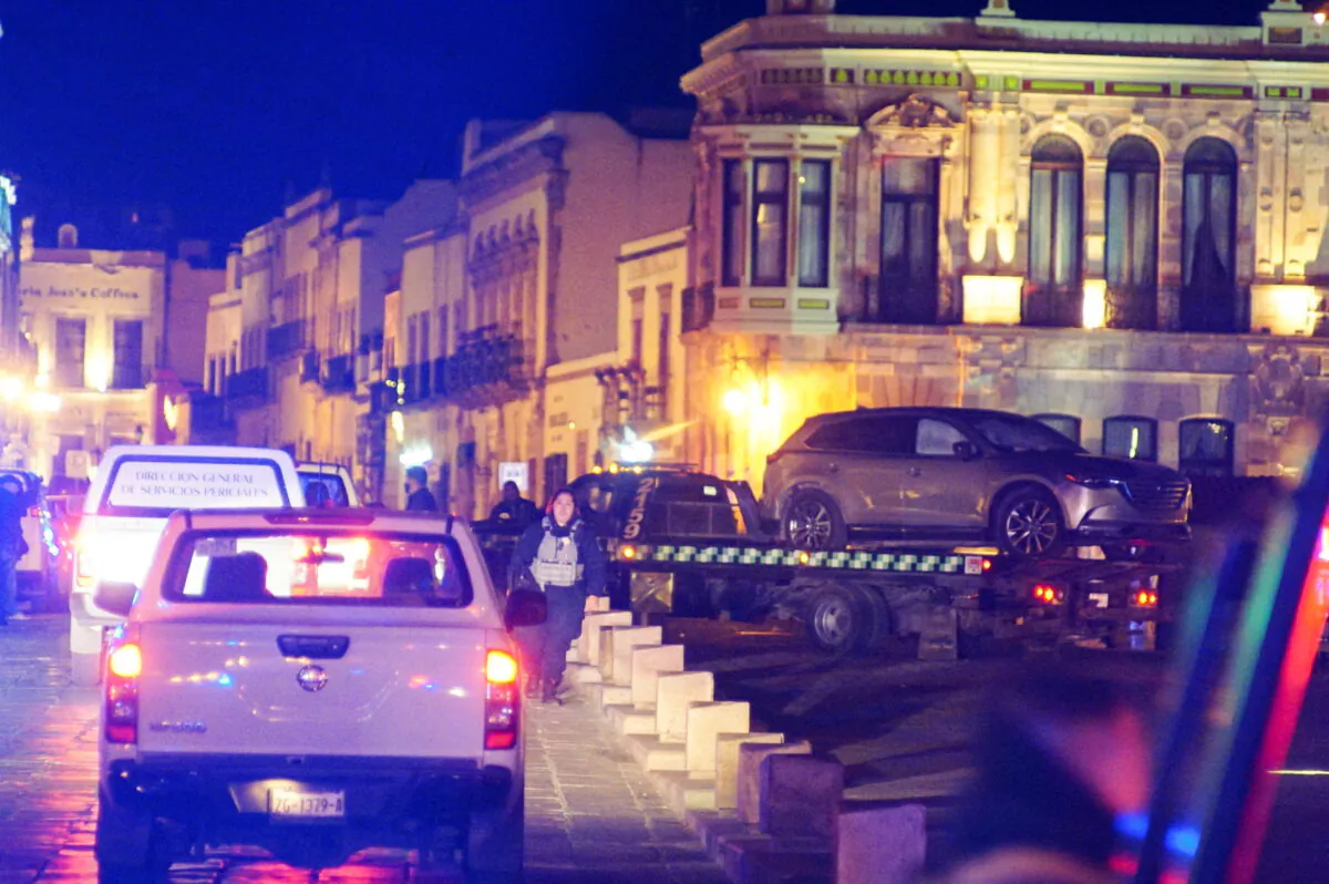 Police forces work at the scene as they remove a vehicle with bodies that were left by unknown assailants in front of the Government Palace, in Zacatecas, Mexico, on Jan. 6, 2022. (Edgar Robledo/Reuters)