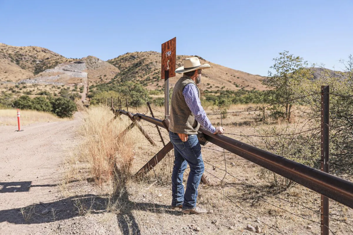 Detective Jake Kartchner with the Cochise County Sheriff’s Office border unit, stands at the U.S.–Mexico border fence that was slated to be replaced with a 30-foot fence before President Joe Biden halted all border wall construction in January 2021, in Cochise County, Ariz., on Dec. 6, 2021. (Charlotte Cuthbertson/The Epoch Times)