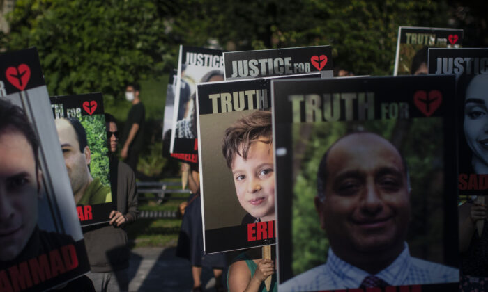 Placards bearing the faces of the victims of Flight PS752 are carried  in Toronto on August 5, 2021. (The Canadian Press/Chris Young)