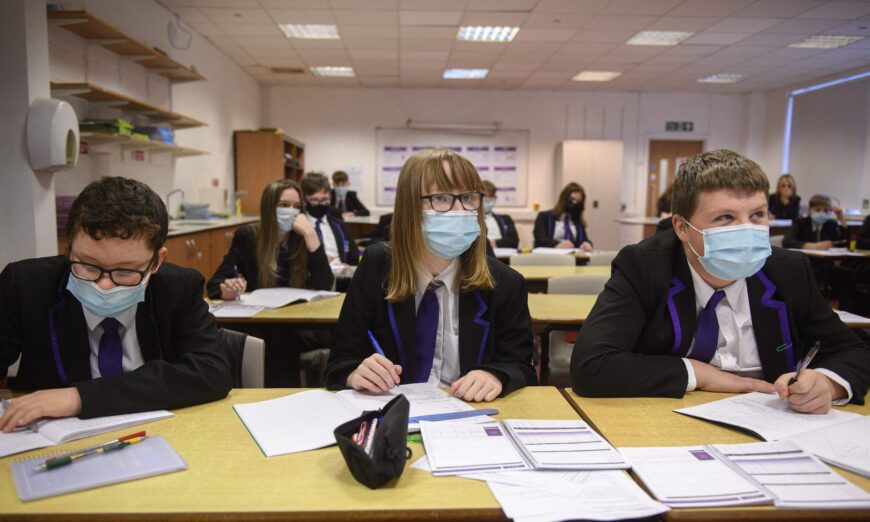 2022 年 1 月 4 日，10 年级学生在参加英格兰西北部哈利法克斯公园巷学院的科学课时戴着口罩。（Oli Scarff/法新社来自 Getty Images）