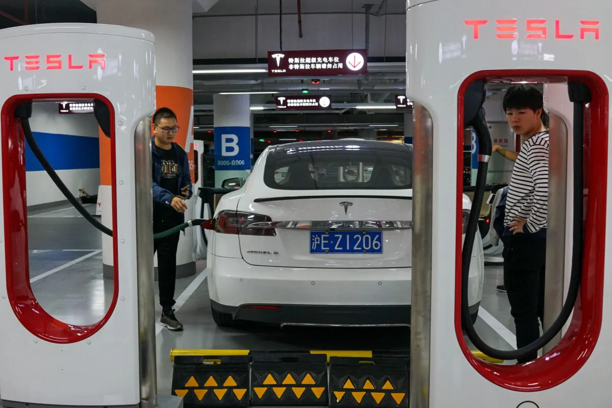 People charge their Tesla vehicles at a charging station inside a mall in Shanghai on October 23, 2017. (Chandan Khanna/AFP via Getty Images)