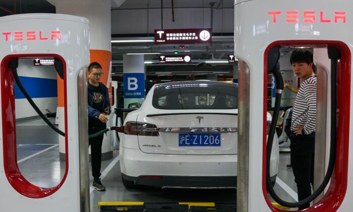 People charge their Tesla vehicles at a charging station inside a mall in Shanghai on October 23, 2017. (Chandan Khanna/AFP via Getty Images)