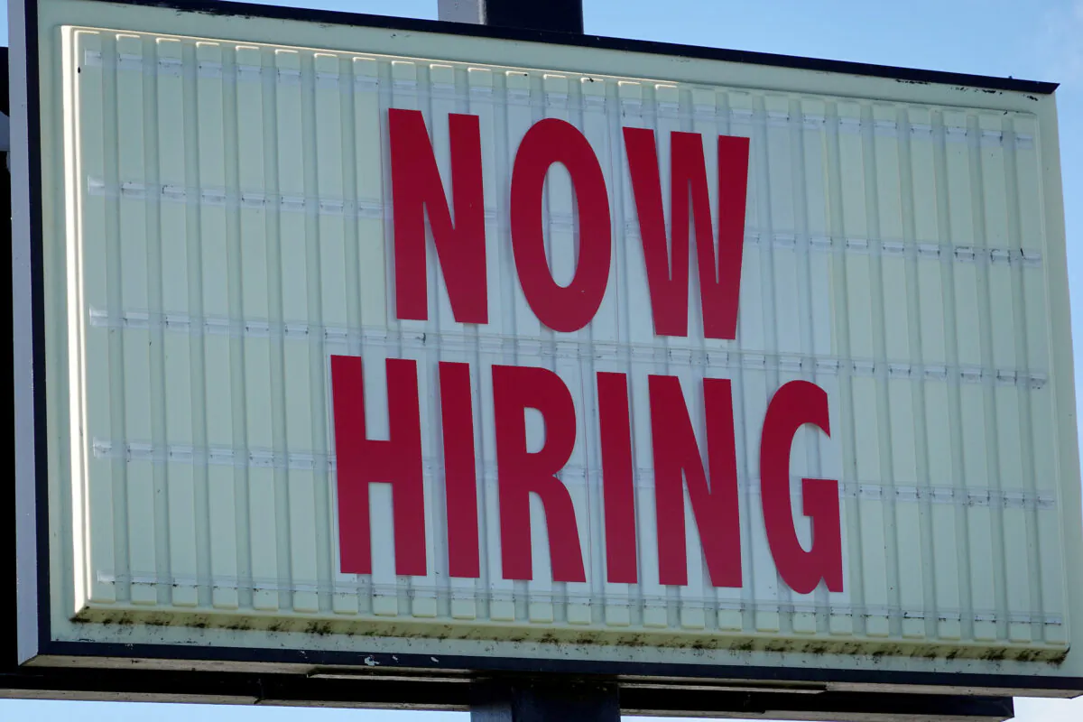 A Now Hiring sign hangs in front of a Winn-Dixie grocery store, in Miami, Fla., on Dec. 03, 2021. (Joe Raedle/Getty Images)