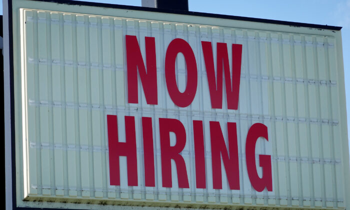 A Now Hiring sign hangs in front of a Winn-Dixie grocery store, in Miami, Fla., on Dec. 03, 2021. (Joe Raedle/Getty Images)