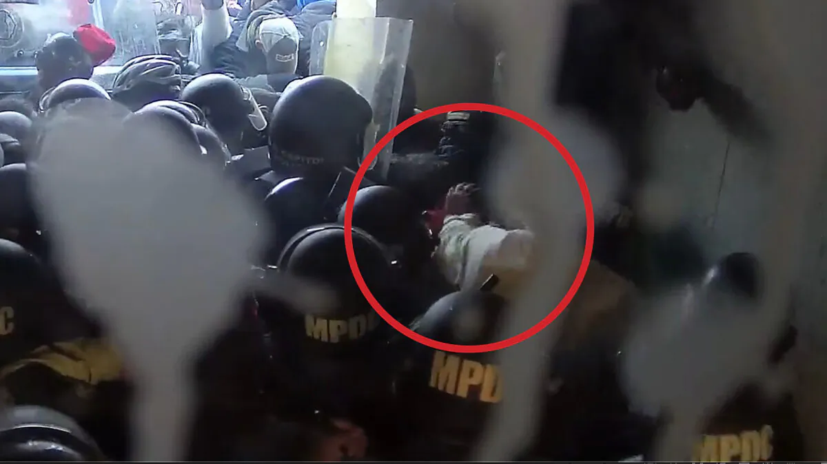 A District of Columbia police officer in white lands a punch with his left fist on Victoria C. White of Rochester, Minn., on Jan. 6, 2021. (Screen Capture/via The Epoch Times)