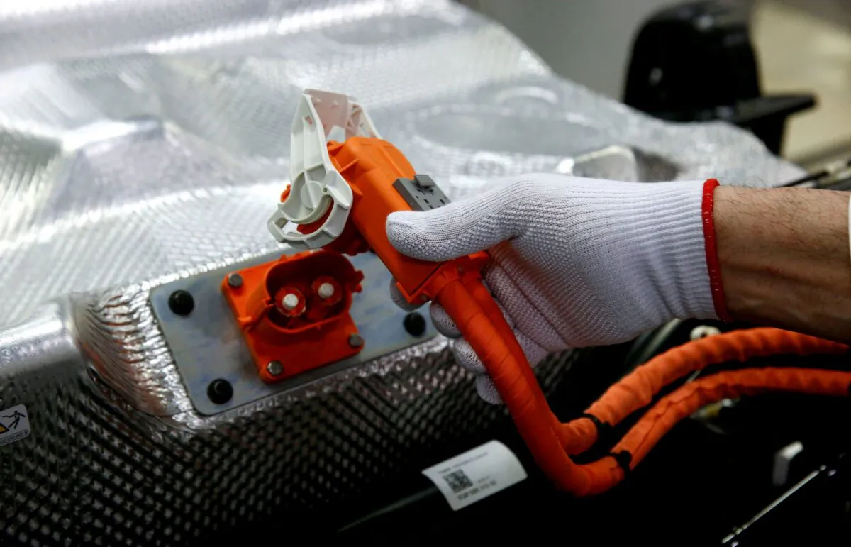 A worker connects the battery during the assembly of an e-Golf electric car at the new production line of the Transparent Factory of German carmaker Volkswagen in Dresden, Germany, on March 30, 2017. (Fabrizio Bensch/Reuters)