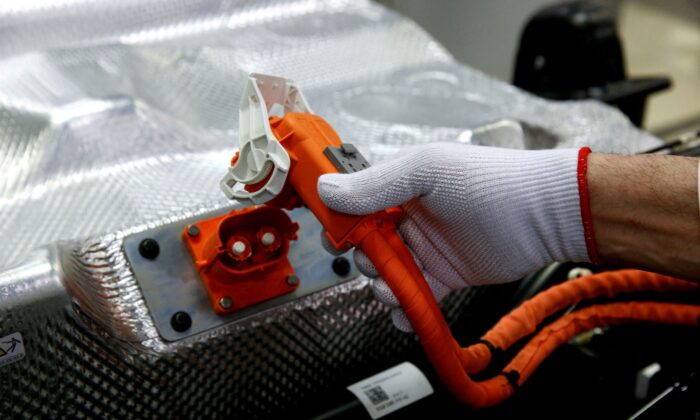 A worker connects the battery during the assembly of an e-Golf electric car at the new production line of the Transparent Factory of German carmaker Volkswagen in Dresden, Germany, on March 30, 2017. (Fabrizio Bensch/Reuters)