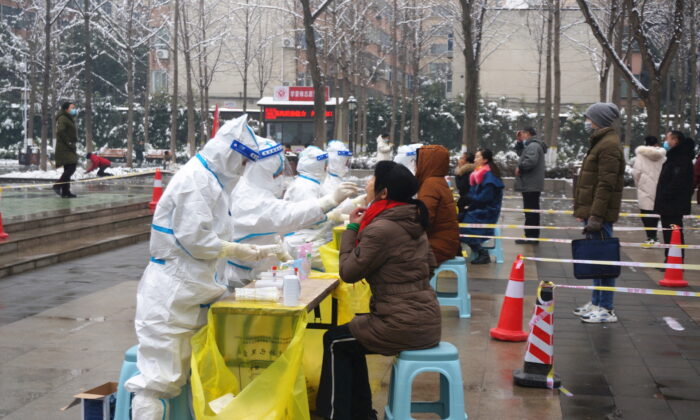 Medical workers in protective suits collect swabs from residents during a citywide nucleic acid testing following cases of COVID-19 in Zhengzhou, Henan Province, China, on Jan. 5, 2022. (CNS photo via Reuters)