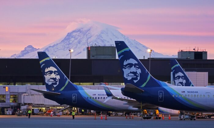 Alaska Airlines planes are parked at gates with Mount Rainier in the background at sunrise,  at Seattle-Tacoma International Airport in Seattle on March 1, 2021. (Ted S. Warren/AP Photo)