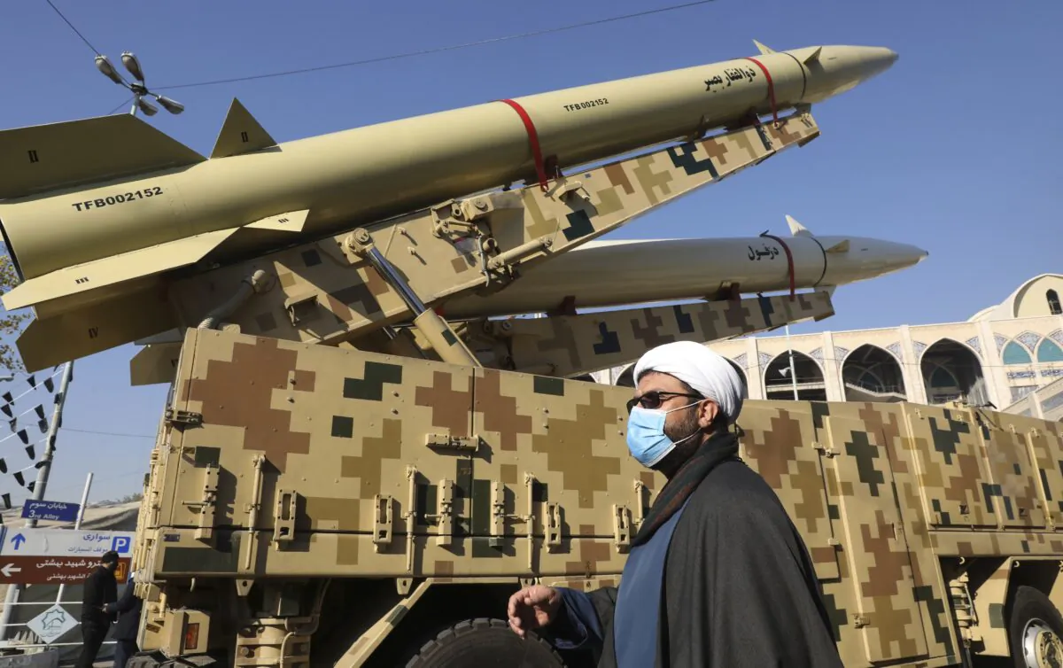 A cleric walks past Zolfaghar, top, and Dezful missiles in Tehran, Iran, on Jan. 7, 2022. (Vahid Salemi/AP Photo)