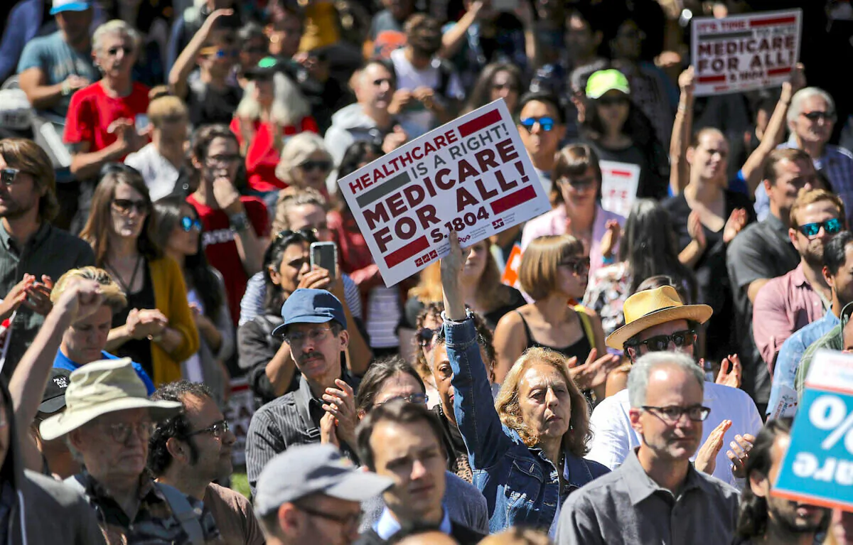 People hold up signs at a health care rally at the 2017 Convention of the California Nurses Association/National Nurses Organizing Committee in San Francisco, on Sept. 22, 2017. (Justin Sullivan/Getty Images)