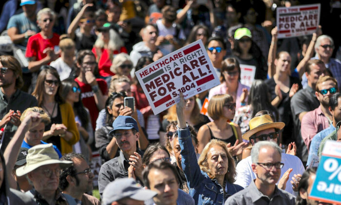 People hold up signs at a health care rally at the 2017 Convention of the California Nurses Association/National Nurses Organizing Committee in San Francisco, on Sept. 22, 2017. (Justin Sullivan/Getty Images)