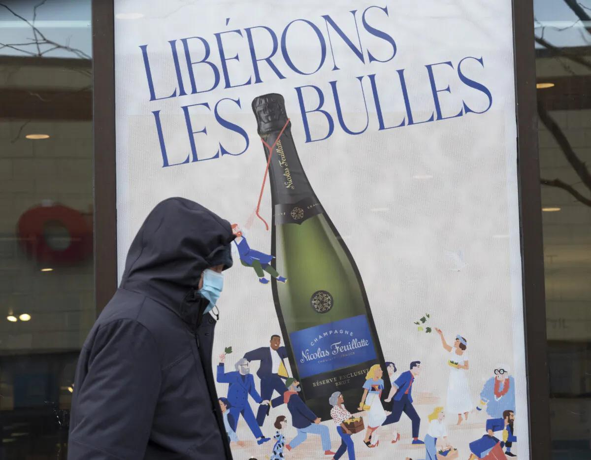 A man walks past a Société des alcools du Québec (SAQ) store in Montreal on Jan. 6, 2022, as Quebec announced that vaccine passports will be required to enter all provincial SAQ liquor stores and Société québécoise du cannabis (SQDC) cannabis outlets effective Jan. 18. (THE CANADIAN PRESS/Ryan Remiorz)