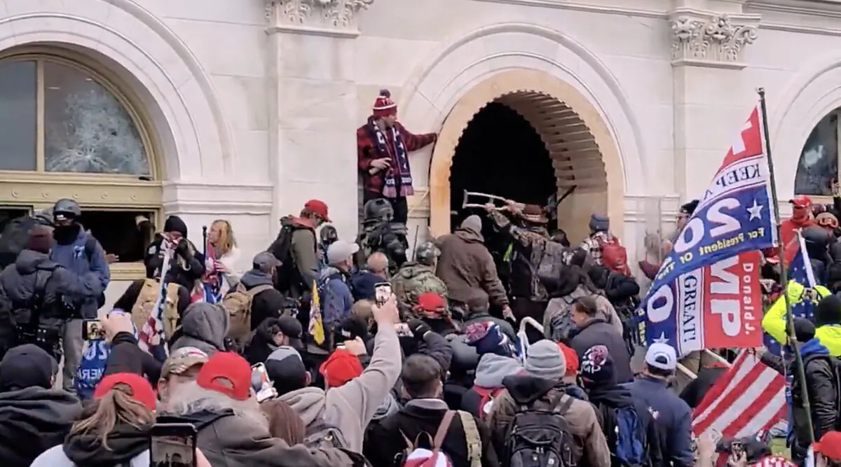 A man points down to where Rosanne Boyland and others tumbled after being pushed from the Capitol tunnel on Jan. 6, 2021. (Screen Capture/via The Epoch Times)