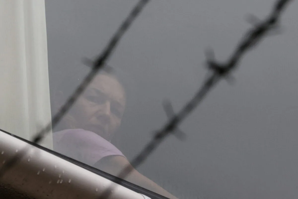 Tennis player Renata Voracova of the Czech Republic looks out a window at the Park Hotel where she is being held while she stays in Australia following the cancellation of her temporary visa, the same government facility where Serbian tennis player Novak Djokovic is being held, in Melbourne, Australia, on Jan. 8, 2022. (Loren Elliott/File Photo/Reuters)