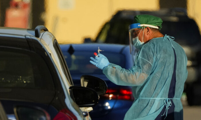 A health care worker tests people for COVID-19 at a drive-up testing center at Tropical Park in Miami, on Dec. 29, 2021. (Rebecca Blackwell/AP Photo)