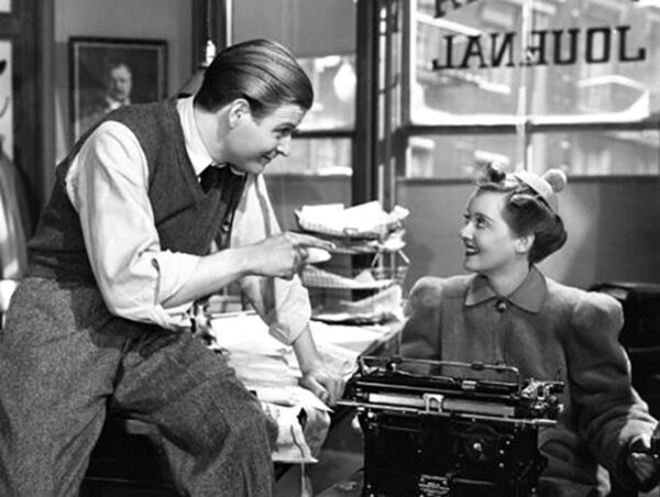 man talking to woman at typewriter