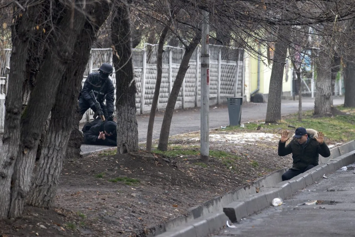 An armed riot police officer detains two protesters during a security operation in a street after clashes in Almaty, Kazakhstan, on Jan. 8, 2022. (Vasily Krestyaninov/AP Photo)