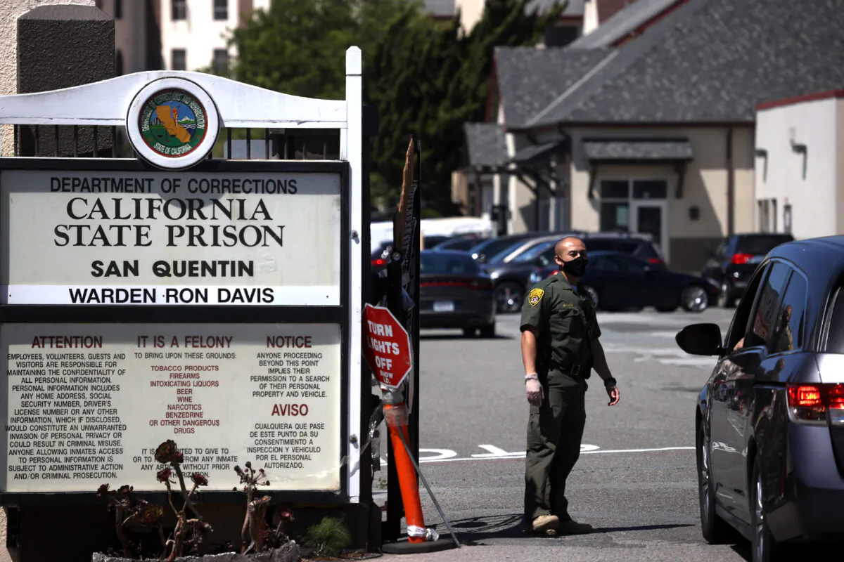 A California Department of Corrections and Rehabilitation officer wears a protective mask as he stands guard at the front gate of San Quentin State Prison in San Quentin, Calif., on June 29, 2020. (Justin Sullivan/Getty Images)