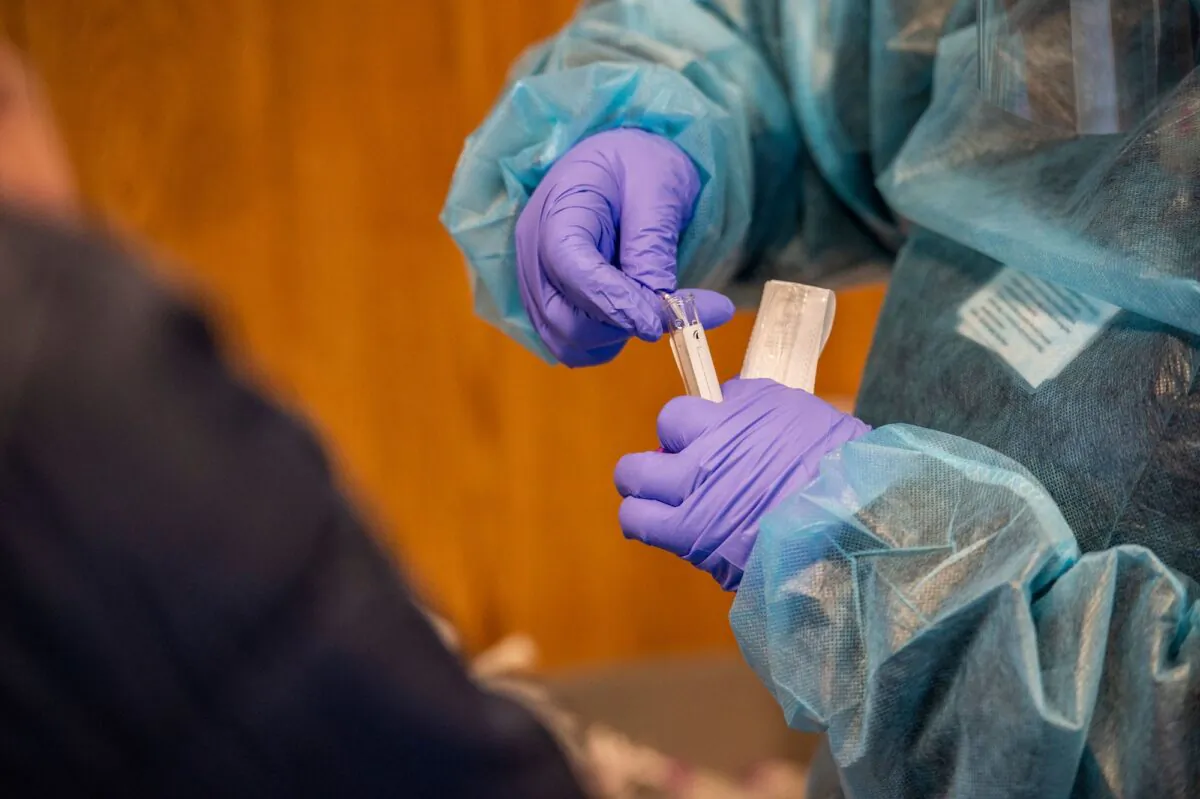 A medical worker places a nasal swab into a test tube after performing a COVID-19 PCR test at East Boston Neighborhood Health Center in Boston, Mass., on Dec. 20, 2021.  (Joseph Prezioso/AFP via Getty Images)