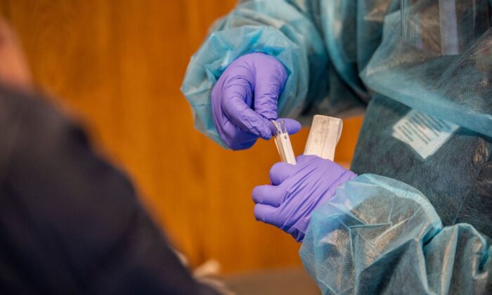 A medical worker places a nasal swab into a test tube after performing a COVID-19 PCR test at East Boston Neighborhood Health Center in Boston, Mass., on Dec. 20, 2021.  (Joseph Prezioso/AFP via Getty Images)