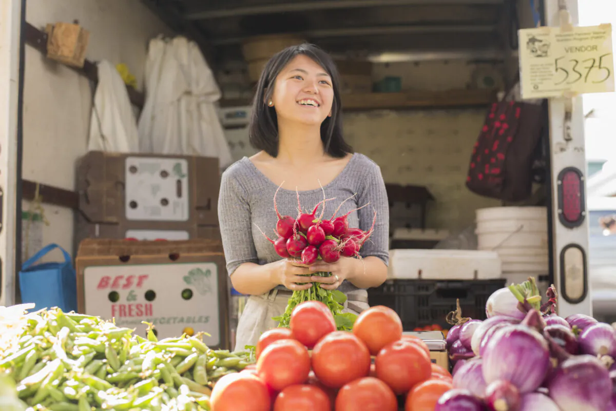 A young woman offers fresh produce for sale at the farmers market in Eau Claire, Wisconsin. (Courtesy of Joe Leute)