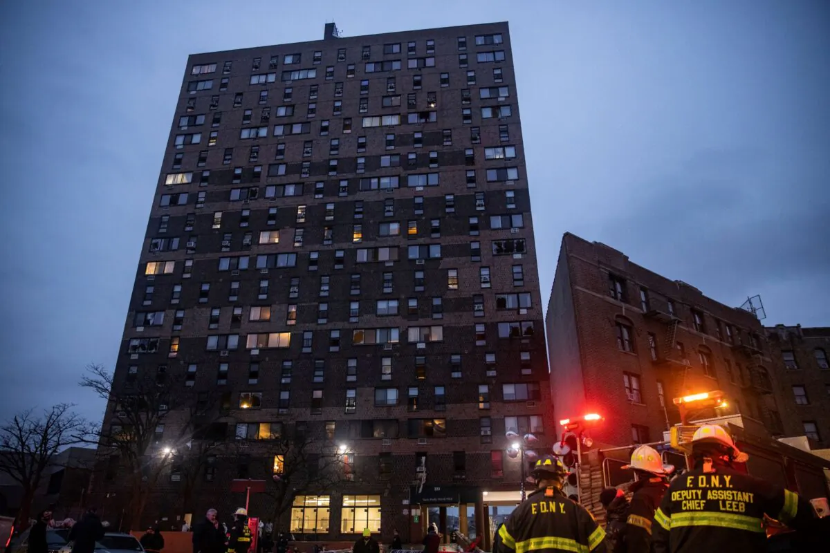 Emergency personnel work at the scene of a fatal fire at an apartment building in the Bronx, New York, on Jan. 9, 2022. (Jeenah Moon/AP Photo)