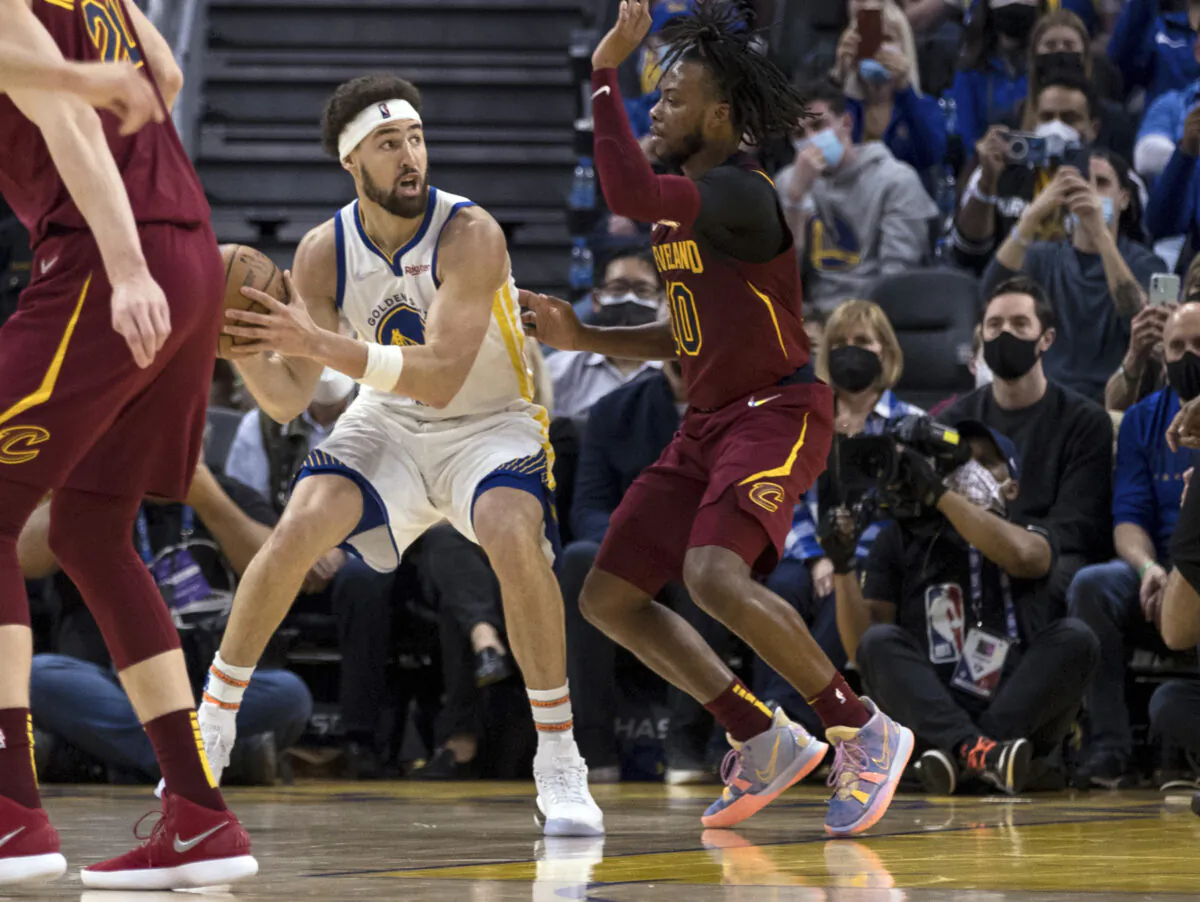 Golden State Warriors guard Klay Thompson (L), looks to pass the ball against Cleveland Cavaliers guard Darius Garland (R), during the first half of an NBA basketball game in San Francisco, on Jan. 9, 2022. (John Hefti/AP Photo)