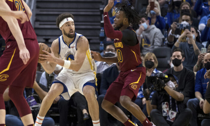 Golden State Warriors guard Klay Thompson (L), looks to pass the ball against Cleveland Cavaliers guard Darius Garland (R), during the first half of an NBA basketball game in San Francisco, on Jan. 9, 2022. (John Hefti/AP Photo)