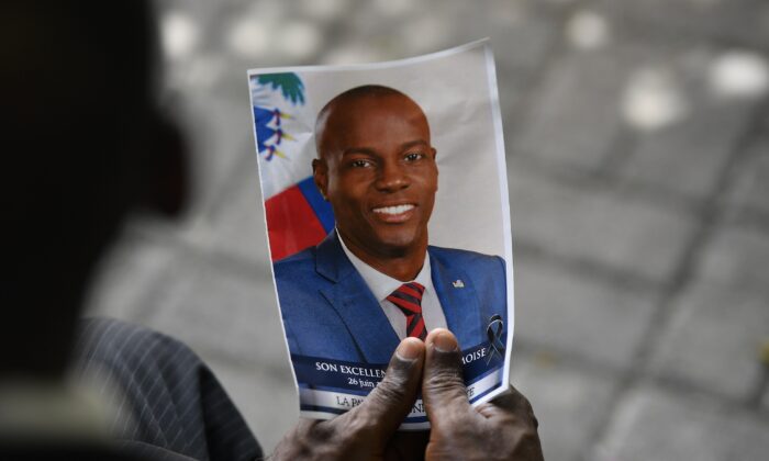 A person holds a photo of late Haitian President Jovenel Moise during his memorial ceremony at the National Pantheon Museum in Port-au-Prince, Haiti, on July 20, 2021. (Matias Delacroix/AP Photo)