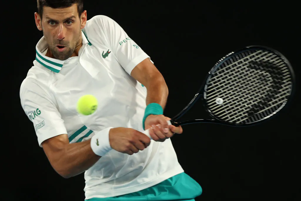 Serbia's Novak Djokovic hits a return against Canada's Milos Raonic during their men's singles match on day seven of the Australian Open tennis tournament in Melbourne, Australia, on Feb. 14, 2021. (Brandon Malone/AFP via Getty Images)