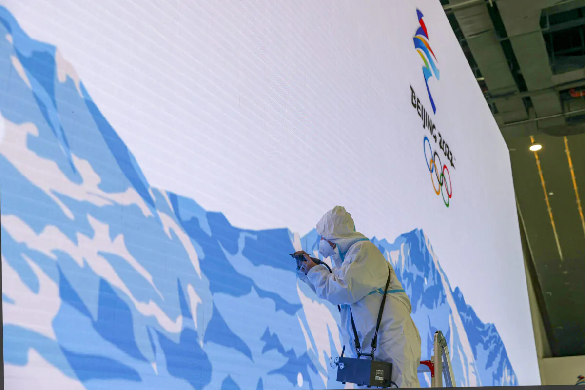 A worker makes repairs to a video wall at the Main Media Center, ahead of opening ceremonies for the Beijing Winter Olympics in February on Jan. 9, 2022, in Beijing. (Katopodis/Getty Images)