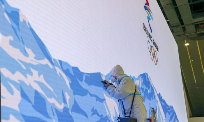 A worker makes repairs to a video wall at the Main Media Center, ahead of opening ceremonies for the Beijing Winter Olympics in February on Jan. 9, 2022, in Beijing. (Katopodis/Getty Images)