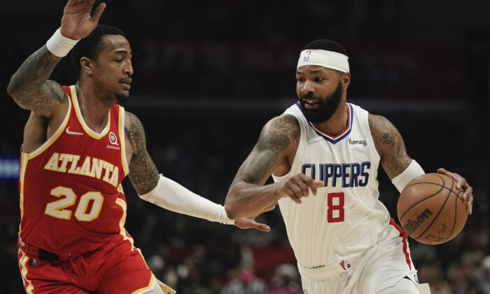 Los Angeles Clippers' Marcus Morris Sr., right, drives past Atlanta Hawks' John Collins during second half of an NBA basketball game in Los Angeles on Jan. 9, 2022. (AP Photo/Jae C. Hong)