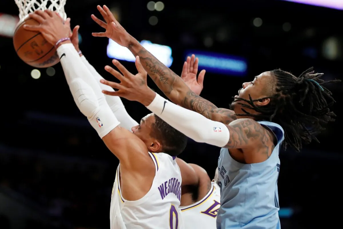 Los Angeles Lakers guard Russell Westbrook, left, grabs a rebound in front of Memphis Grizzlies guard Ja Morant, right, during the first half of an NBA basketball game in Los Angeles, on Jan. 9, 2022. (Alex Gallardo/AP Photo)