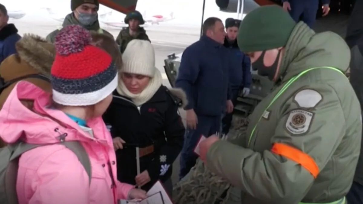 This still image taken from a video shows Russian citizens boarding a military evacuation plane as authorities have their documents checked in Kazakhstan on Jan. 9, 2021. (The Russian Defense Ministry via AP)