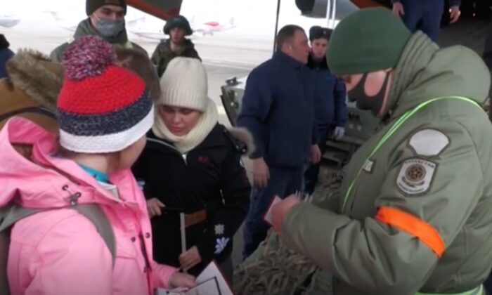 This still image taken from a video shows Russian citizens boarding a military evacuation plane as authorities have their documents checked in Kazakhstan on Jan. 9, 2021. (The Russian Defense Ministry via AP)