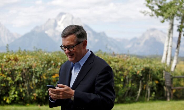 Federal Reserve Vice Chair Richard Clarida reacts as he holds his phone during the three-day 