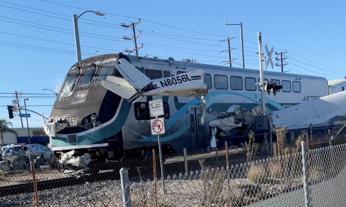 A train hits an aircraft that crashed on railway tracks in Los Angeles, Calif., on Jan. 9, 2022, in this screen grab from a social media video. (Luis Jimenez/via Reuters)